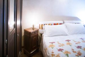 una camera con letto e comodino in legno di I Chimi Locanda di Frassino a Frassino