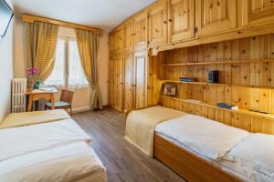 2 letti in una camera con pareti in legno di Hotel Aquila a Cortina dʼAmpezzo