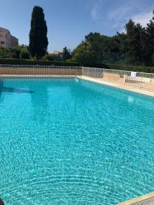 a large swimming pool with blue water at Cap Paradise suite jacuzzi in Cap d'Agde