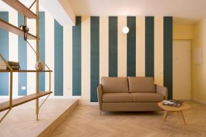 un soggiorno con divano e parete a righe di Metropolitan Suites ad Ancona