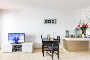 comedor con mesa y TV en un armario blanco en Apartment Princesa Bitacora, en Puerto del Carmen