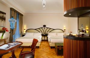 a hotel room with two beds and a table at Grand Hotel Savoia in Genoa