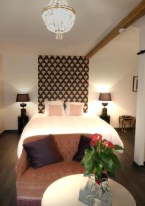 Maison du figuier في Lancié: غرفة نوم بسرير وطاولة مع أريكة