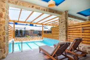 a patio with two chairs and a swimming pool at Haven Beach in Faliraki
