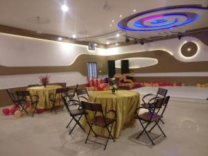 a banquet hall with two tables and chairs and a large ceiling at Shivam Palace & Resort in Jodhpur