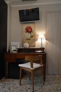 a desk with a chair and a table with a lamp at Musica Guest House in Alghero