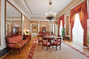 a living room with a table and chairs and a chandelier at Grand Hotel in Krakow