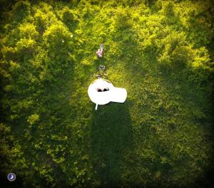 a person sitting in the grass with a white table at Guarda Che Luna in Sasso di Castalda