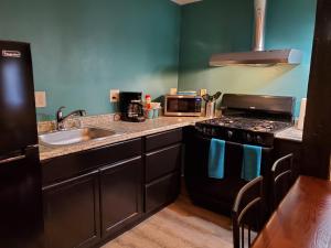a kitchen with a sink and a stove at PineCrest Inn & Suites in Flagstaff +27 photos