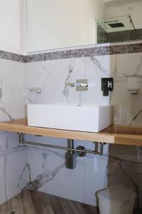 a white sink on a counter in a bathroom at Clelia's Boutique Rooms & Suites in La Maddalena +56 photos