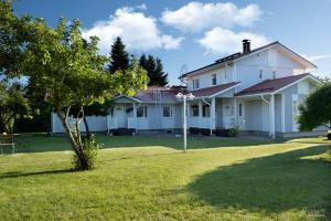 une maison blanche avec un moulin à vent dans la cour dans l'établissement Westbay Inn, à Vaasa