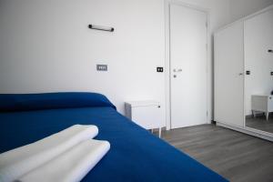 een slaapkamer met een blauw bed en een spiegel bij Hotel B&B Sole in Senigallia