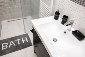 E13 - Elegant Apartment في بودابست: حمام مع حوض أبيض ودش