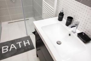 a bathroom with a white sink and a shower at E13 - Elegant Apartment in Budapest +10 photos
