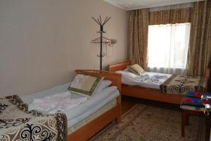 een slaapkamer met 2 bedden en een raam bij Zheenkan2 in Naryn
