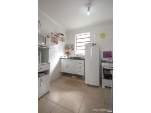 uma cozinha branca com um frigorífico e um fogão em Mariano - JK pertinho de tudo! em Porto Alegre