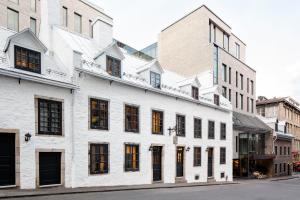 a white building with black windows on a street at William Gray by Gray Collection in Montreal