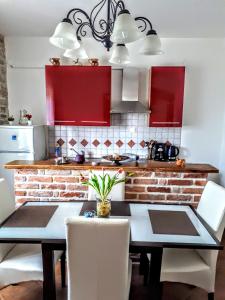 a kitchen with red cabinets and a table and chairs at Apartments Relax Zone in Umag +83 photos