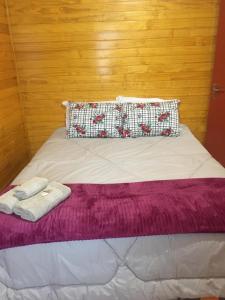 uma cama com duas toalhas em cima em Casa de férias flor das acácias em Urubici