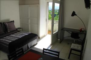 a bedroom with a bed and a desk and a window at Studios Corte Restonica in Corte