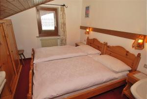 um quarto com uma cama grande e um lavatório em Appartamento trilocale nr. 5 em Livinallongo del Col di Lana
