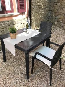 a black table and chairs with a bottle of wine at Appartment- Betulla in Apecchio