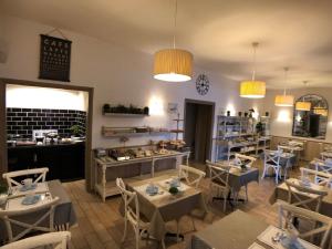 a restaurant with tables and chairs in a room at Hôtel des Druides in Quiberon