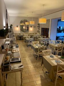 a restaurant with tables and chairs in a room at Hôtel des Druides in Quiberon