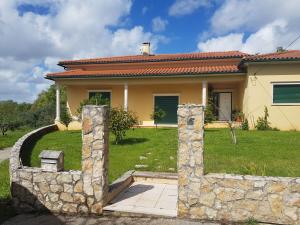 una casa con una recinzione di pietra di fronte di Casa da Floresta a Santiago da Guarda