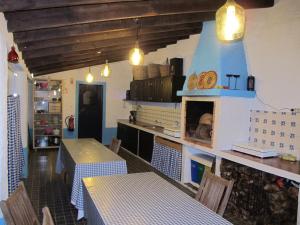 リベイラ・グランデにあるParque de Campismo Rural Quinta das Laranjeirasのレストランには2つのテーブルとキッチン付きカウンターがあります。