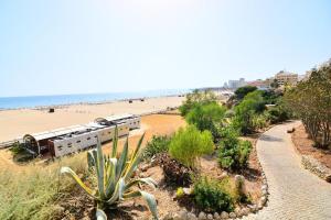 a train on a track next to a beach at Luz Apartments in Portimão