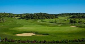 a view of a green golf course with a bunker at Luz Apartments in Portimão