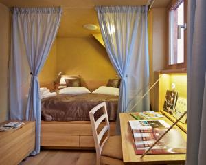 una camera da letto con un letto con tende blu e un tavolo di Café FARA a Klentnice