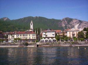 a town with a clock tower next to a body of water at Baveno mono in Baveno