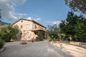 stary kamienny budynek z podjazdem przed nim w obiekcie Agriturismo Il Giardino Dei Ciliegi w mieście Passaggio Di Assisi