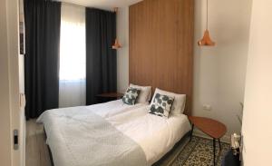 - une chambre avec un lit doté de draps et d'oreillers blancs dans l'établissement Kite Apart, à Mechelinki
