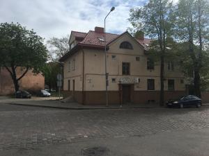 une vieille maison avec une voiture garée devant elle dans l'établissement Kanto studija, à Klaipėda