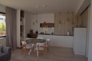 a kitchen and dining room with a table and chairs at Kite Apart in Mechelinki