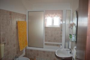 baño con lavabo, espejo y ventana en Holidays 71, en Nazaré
