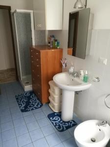La salle de bains est pourvue d'un lavabo, de toilettes et d'une douche. dans l'établissement At Claudio and Inna's Home, à Catane