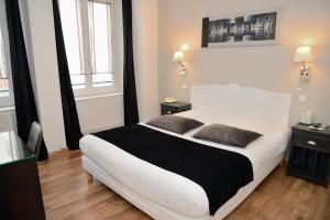 een slaapkamer met een groot wit bed en 2 ramen bij EtC...Hôtel - Strasbourg Hyper Centre in Straatsburg