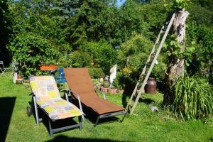 a couple of chairs and a ladder in the grass at Fewo Jule in Thaleischweiler-Fröschen