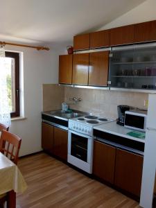 a kitchen with wooden cabinets and a white stove top oven at Apartments Dora in Medulin