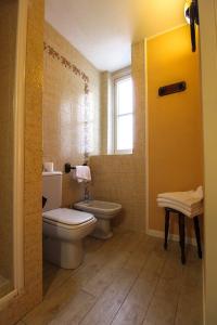 La salle de bains est pourvue de toilettes et d'un lavabo. dans l'établissement Hotel Moderno, à Premeno