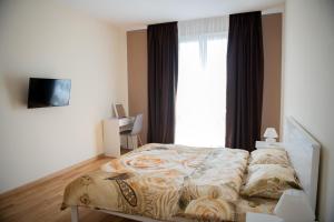 um quarto com uma cama e uma grande janela em AvalonRestApartments em Lviv