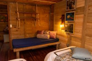 um quarto com uma cama num chalé de madeira em Palmas de Cocora em Salento