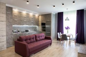 sala de estar con sofá púrpura y mesa en AvalonRestApartments, en Leópolis