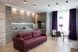 a living room with a purple couch and a table at AvalonRestApartments in Lviv