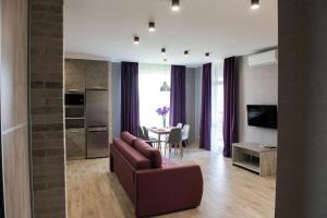 a living room with a couch and a kitchen and a table at AvalonRestApartments in Lviv
