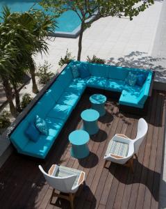a blue couch and tables and chairs on a patio at Zota Beach Resort in Longboat Key